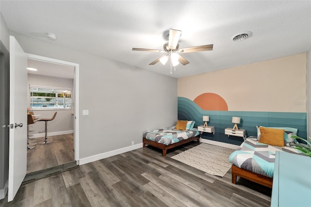 bedroom featuring ceiling fan, hardwood / wood-style floors, and a textured ceiling