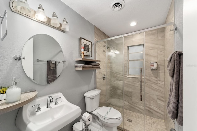 bathroom featuring sink, a shower with door, a textured ceiling, and toilet