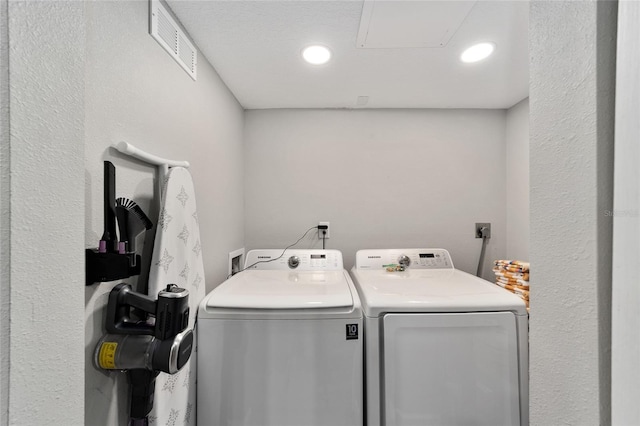 laundry room with independent washer and dryer and a textured ceiling