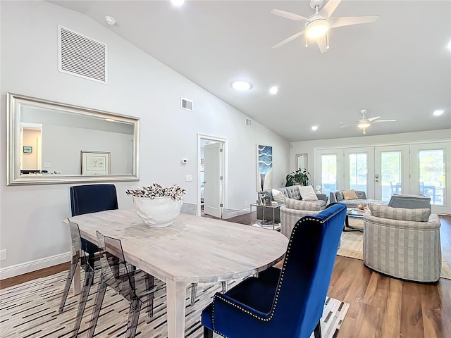 dining area with hardwood / wood-style floors, ceiling fan, high vaulted ceiling, and french doors