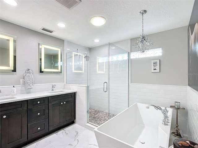 bathroom featuring vanity, a textured ceiling, tile walls, a chandelier, and shower with separate bathtub