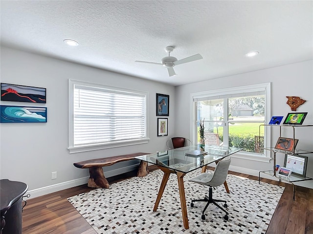 office featuring ceiling fan, dark wood-type flooring, and a wealth of natural light