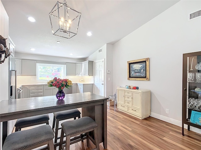 dining area featuring light hardwood / wood-style flooring and a notable chandelier