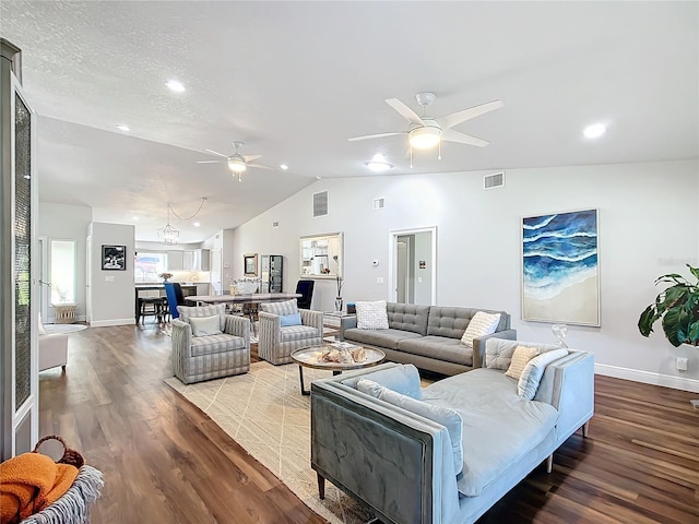 living room featuring ceiling fan with notable chandelier, wood-type flooring, a textured ceiling, and vaulted ceiling