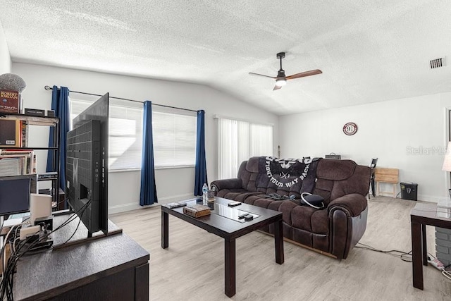 living room featuring a textured ceiling, light hardwood / wood-style floors, vaulted ceiling, and ceiling fan