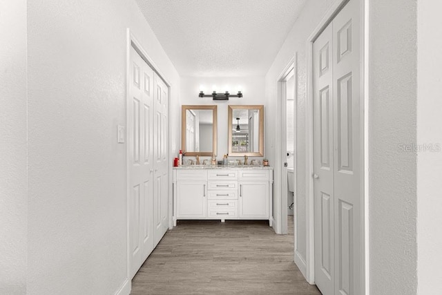 bathroom with hardwood / wood-style flooring, vanity, toilet, and a textured ceiling