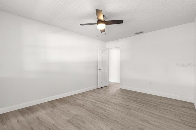 unfurnished room featuring ceiling fan, wood-type flooring, and a textured ceiling