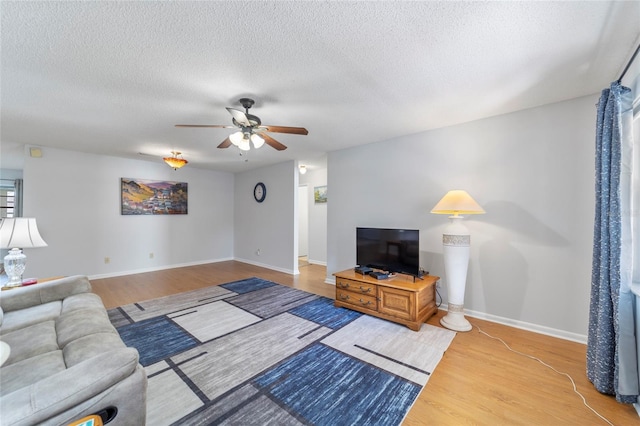 living room with ceiling fan, hardwood / wood-style floors, and a textured ceiling