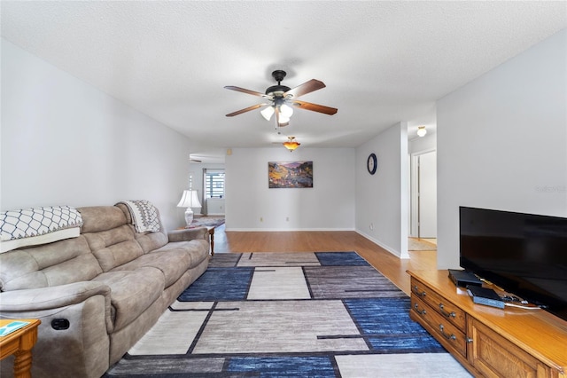 living room featuring a textured ceiling, ceiling fan, and dark hardwood / wood-style floors