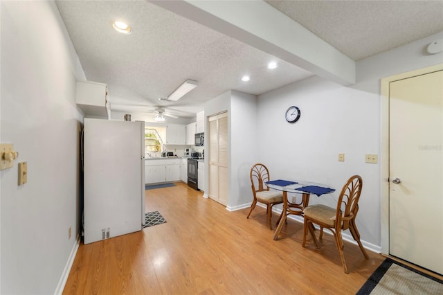 dining room with ceiling fan, light hardwood / wood-style floors, and a textured ceiling