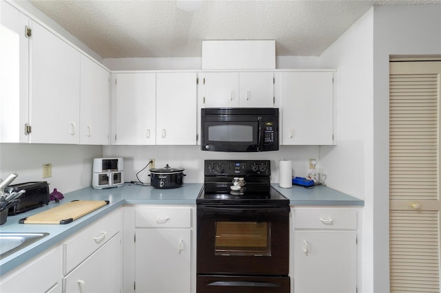 kitchen with black appliances, white cabinets, and a textured ceiling