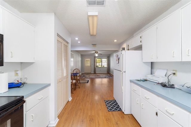 kitchen with white cabinetry, ceiling fan, white refrigerator, a textured ceiling, and light wood-type flooring