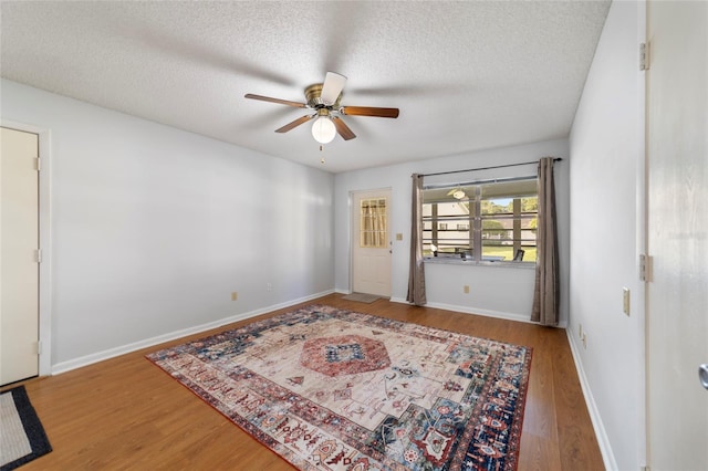 spare room featuring hardwood / wood-style flooring, ceiling fan, and a textured ceiling