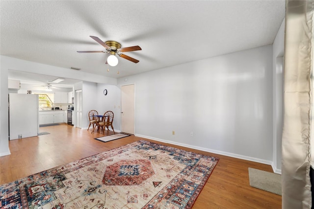 unfurnished room featuring hardwood / wood-style floors, ceiling fan, and a textured ceiling