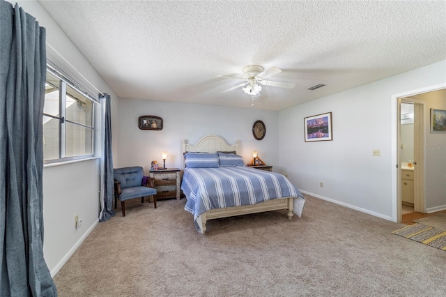 carpeted bedroom featuring ceiling fan, ensuite bathroom, and a textured ceiling