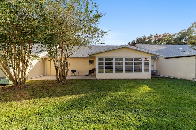 back of house with a sunroom, a patio area, and a yard