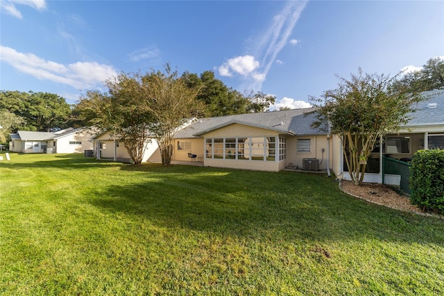 back of house with a lawn and central AC unit