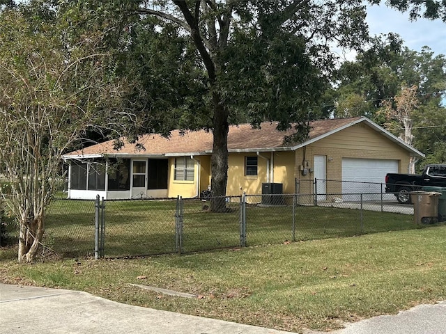 view of front of home featuring a front yard, a garage, central AC unit, and a sunroom