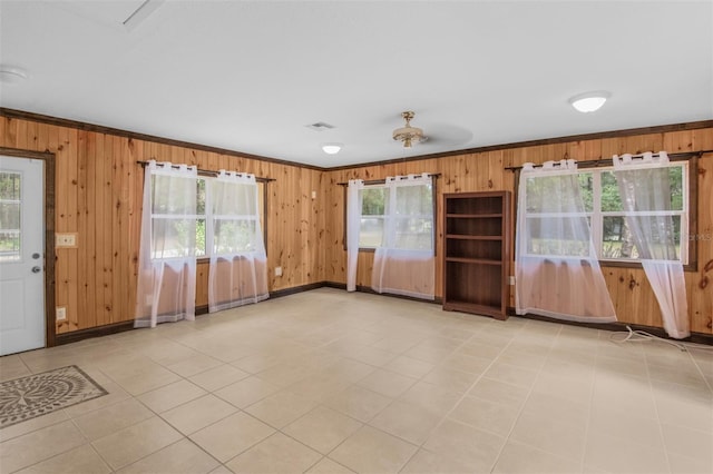 tiled empty room with a wealth of natural light and wood walls