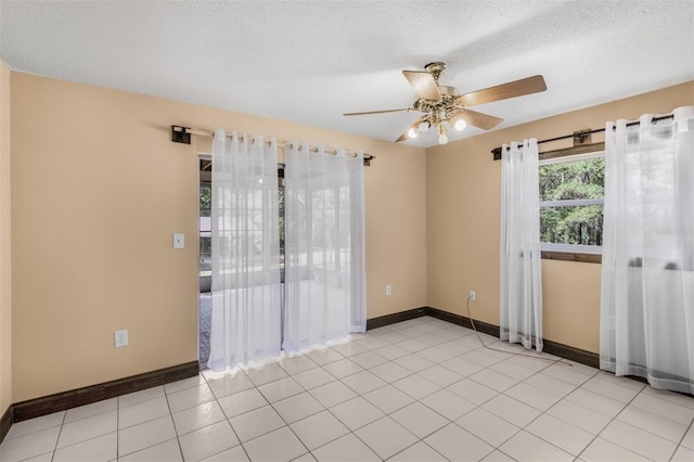 tiled spare room featuring ceiling fan and a textured ceiling