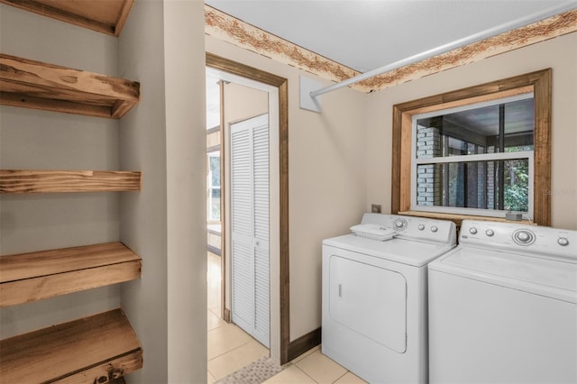 laundry room featuring washing machine and dryer and light tile patterned floors