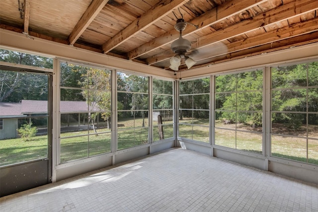 unfurnished sunroom featuring beam ceiling, ceiling fan, a healthy amount of sunlight, and wood ceiling