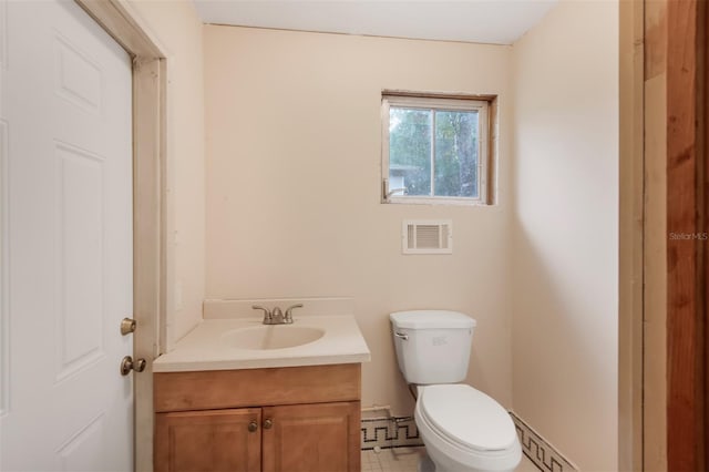 bathroom with tile patterned floors, vanity, toilet, and a baseboard heating unit