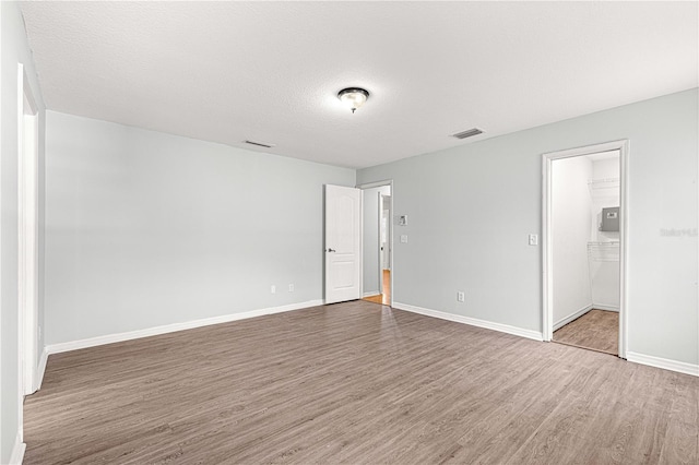 empty room featuring wood-type flooring and a textured ceiling