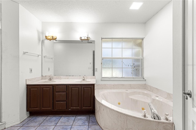 bathroom featuring vanity, a textured ceiling, tile patterned floors, and a bathing tub