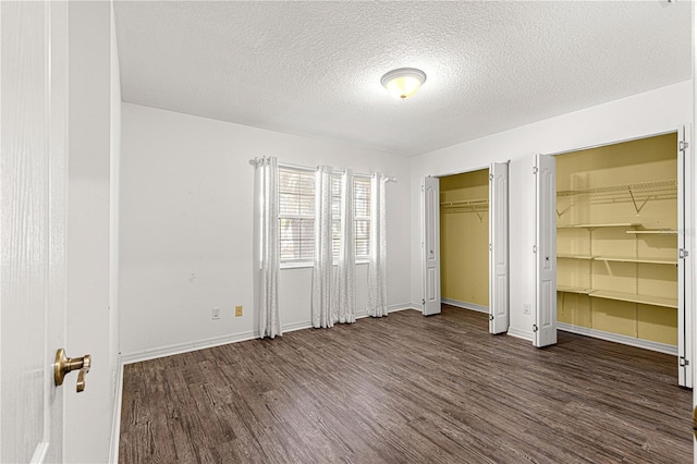 unfurnished bedroom with a textured ceiling and dark wood-type flooring