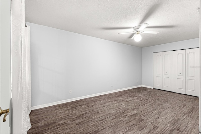 unfurnished bedroom featuring ceiling fan, dark hardwood / wood-style flooring, a textured ceiling, and a closet