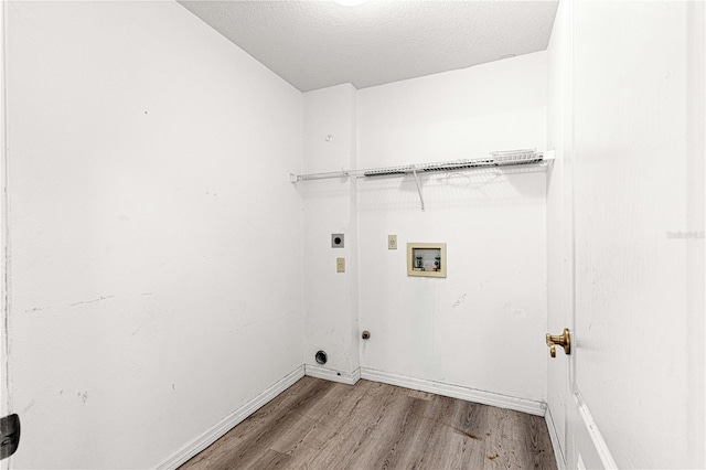 clothes washing area featuring hardwood / wood-style floors, electric dryer hookup, a textured ceiling, and washer hookup