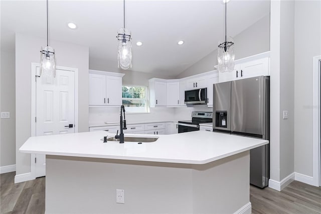 kitchen with white cabinetry, sink, stainless steel appliances, vaulted ceiling, and a kitchen island