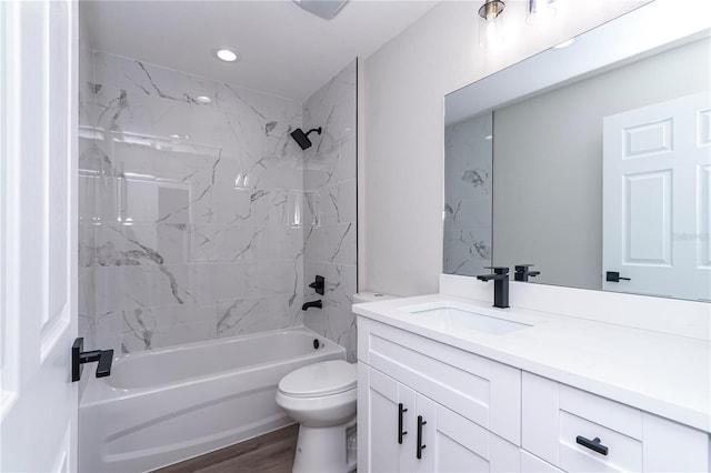 full bathroom with vanity, tiled shower / bath combo, hardwood / wood-style flooring, and toilet