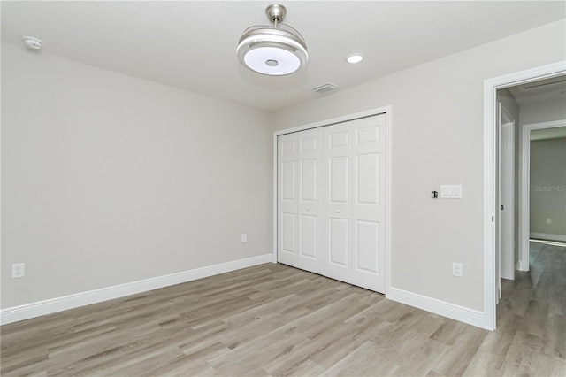 unfurnished bedroom with light hardwood / wood-style floors and a closet