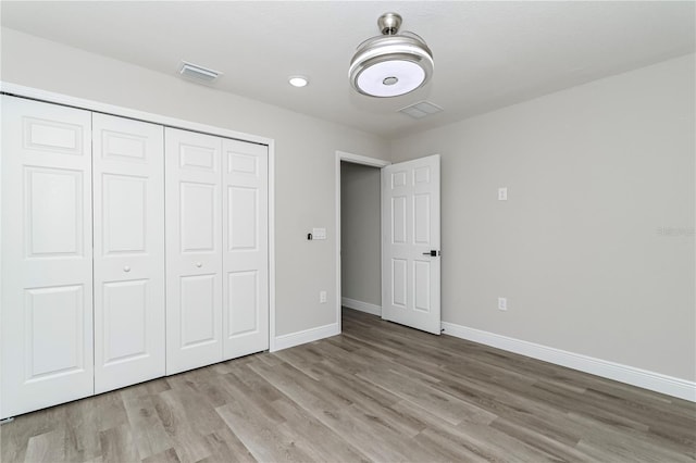 unfurnished bedroom featuring light wood-type flooring and a closet