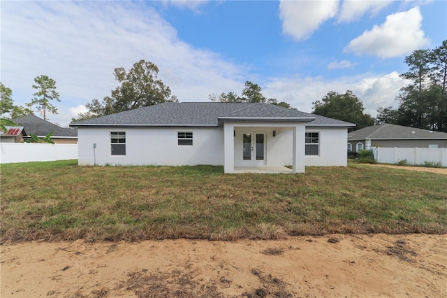 back of house featuring a yard and french doors