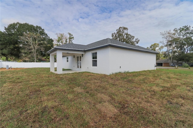 back of property featuring a lawn