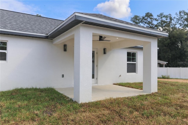 view of exterior entry with a yard, a patio, and ceiling fan