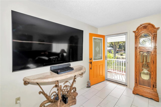 foyer entrance featuring light tile patterned flooring and a textured ceiling