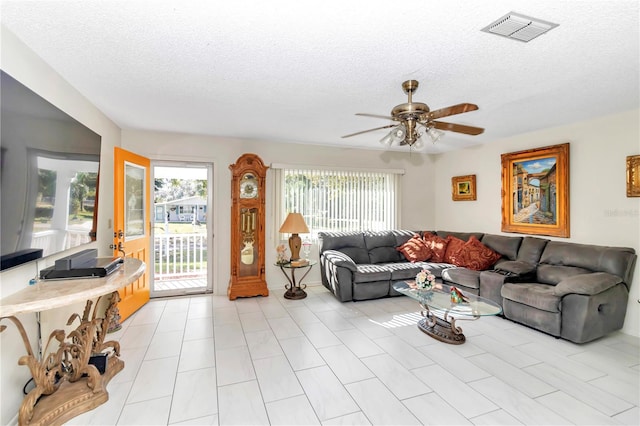 tiled living room featuring a textured ceiling and ceiling fan