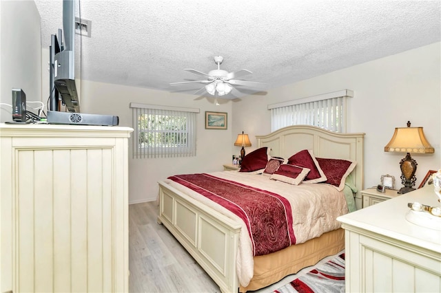 bedroom featuring ceiling fan, a textured ceiling, and light hardwood / wood-style flooring