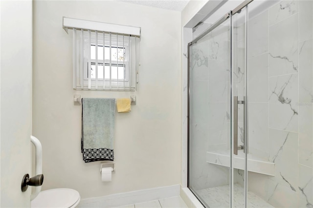 bathroom with tile patterned floors, a shower with shower door, and toilet