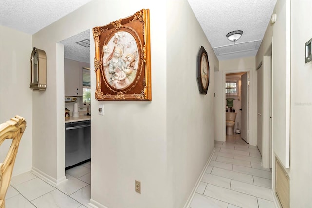 hallway with light tile patterned flooring and a textured ceiling