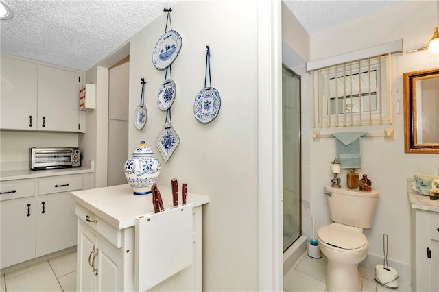 interior space featuring white cabinets, light tile patterned floors, and a textured ceiling