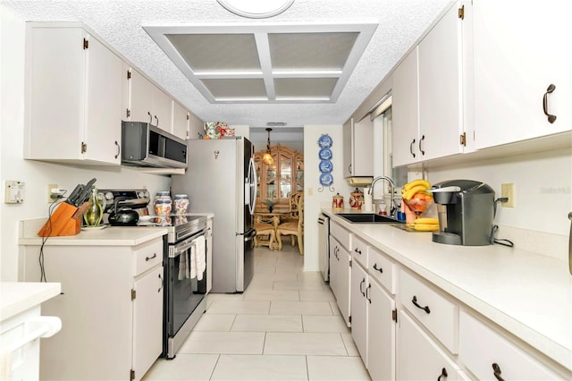 kitchen with sink, light tile patterned floors, a textured ceiling, white cabinetry, and stainless steel appliances