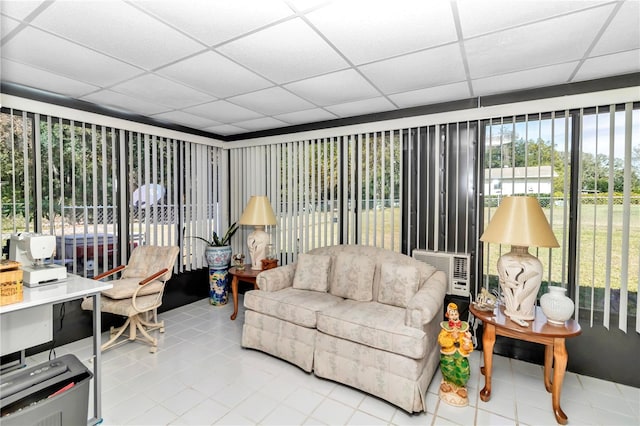 living room featuring tile patterned flooring and a paneled ceiling