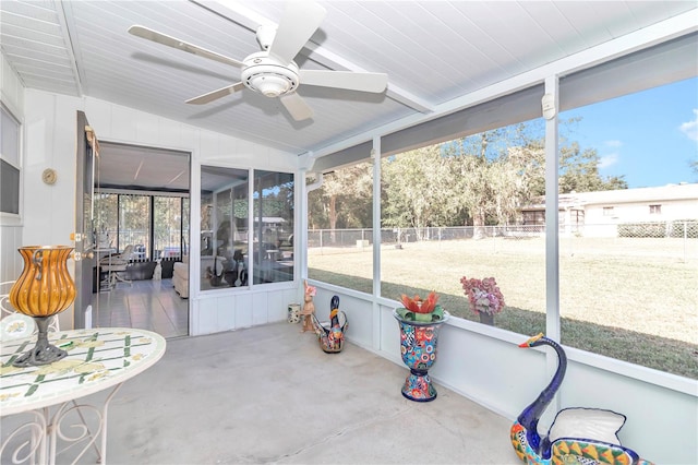 sunroom with ceiling fan, a healthy amount of sunlight, and lofted ceiling