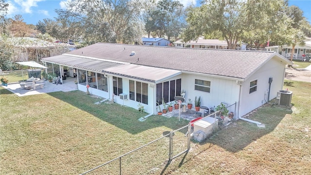 rear view of property featuring central air condition unit, a sunroom, a yard, and a patio