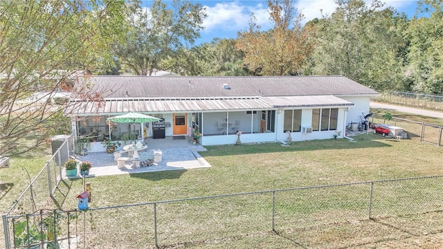 view of front facade with a front yard, a patio area, and a sunroom